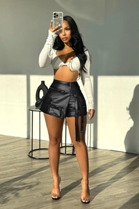 Close-up of high-waist black leather cargo shorts with multi-zipper pockets and long straps