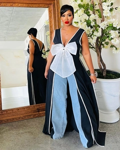 Dettaglio dell'elegante fiocco oversize in organza bianca su un top lungo nero senza maniche