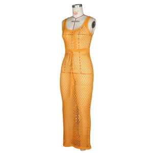 Détail d'une jupe longue au crochet orange montrant la texture ajourée et le cordon à gland