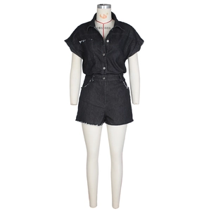 Close-up of black denim romper detailing button closure and distressed raw hem edges