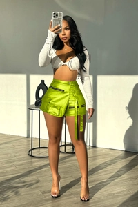 Detail of high-stretch neon green satin cargo shorts with zipper and utility pockets