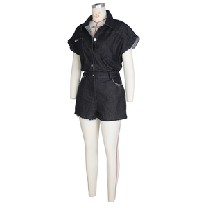 Detail view of black denim romper showing short sleeves and frayed raw hem edges