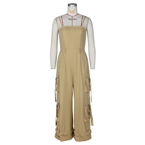 Detail of khaki cargo jumpsuit showing multiple utility pockets and adjustable hem straps