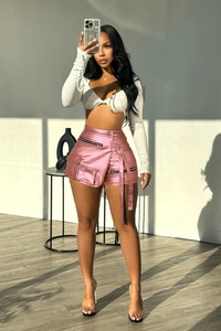 Detail of high-waisted metallic pink cargo shorts with large pockets and long belt