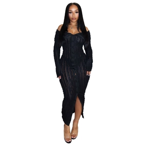 Detail of off-shoulder black knit dress featuring button-down front and side slit