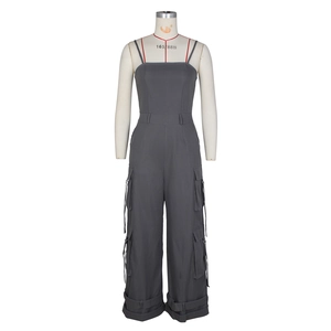 Detail view of dark grey cargo jumpsuit with multiple pockets and wide leg cut
