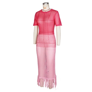 Détail de la maille ajourée et de l'ourlet à franges dégradé rose de la robe de plage