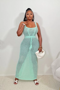 Détail de la robe en maille vert menthe avec motif ajouré et lien de taille à pompon