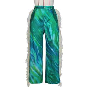 Detail of blue and green marble print pants with long white fringe side tassels