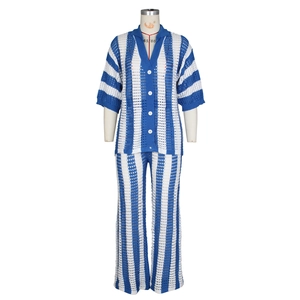Détail du tricot ajouré à rayures bleues et blanches avec boutons blancs sur le cardigan