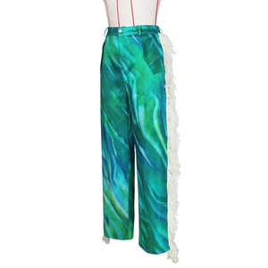 Detail of high-waist trousers featuring marble print and long white side fringe accents