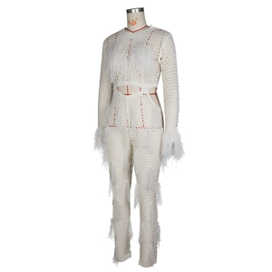 Detailed view of white crochet mesh texture and delicate feather trim on the sleeve and hem
