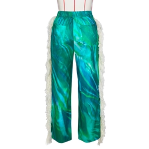 Detail of marble print trousers featuring long white side fringes and elastic waistband