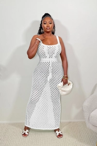 Détail de la robe longue au crochet blanc avec motifs en losanges et cordon de serrage à glands