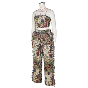 Macro detail of high-quality jacquard floral fabric and side tassel fringe on stylish trousers