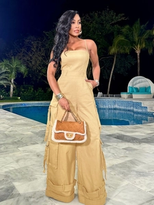 Detail of khaki cargo jumpsuit featuring large side pockets and drawstring hem design