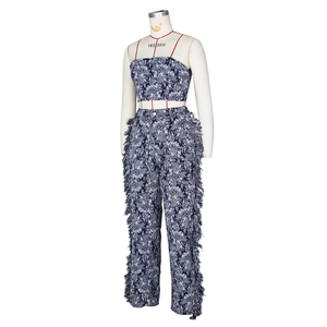 Detail of blue and white damask print pants with dense fringe trim on the side seams