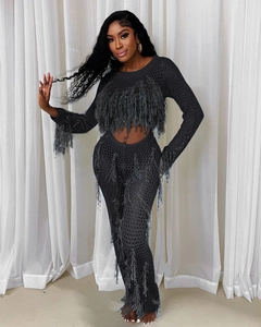 Detail of grey knitted hollow two-piece set with elegant fringe and textured mesh