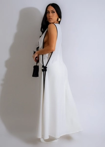 Detail of white halter maxi dress with side cutouts and black decorative bows