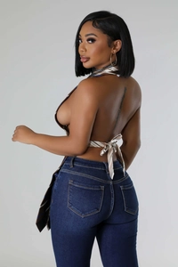 Detail of striped halter top featuring an open-back design with adjustable waist ties