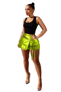 Detailed view of neon green satin cargo shorts with zipper pockets and waist tie