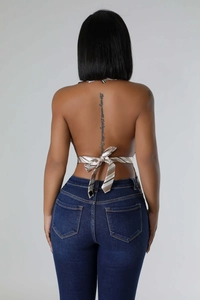 Detail of a brown striped silk halter top with an open back and criss-cross tie design