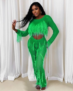 Detail of bright green crochet two-piece set with long fringe and hollow knit texture