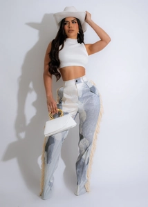 Detail view of stylish printed trousers featuring long decorative fringe along the leg seams
