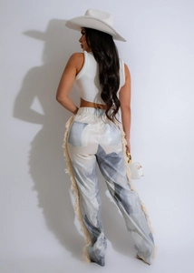 Detail of bohemian floral pants with fringe trim and blue abstract print on the side