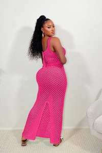 Détail de la robe longue au crochet rose vif avec des motifs floraux ajourés complexes