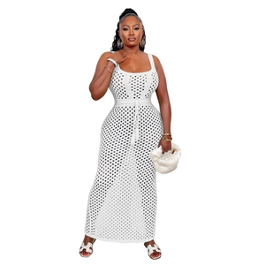 Gros plan sur une robe longue en crochet blanc avec maille ajourée et cordon à pompons
