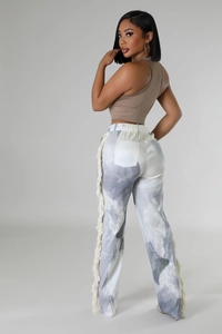 Detail of high waist trousers featuring grey tie-dye print and decorative long side fringe