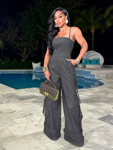 Detail of dark grey strapless jumpsuit featuring utility pockets and wide leg cut