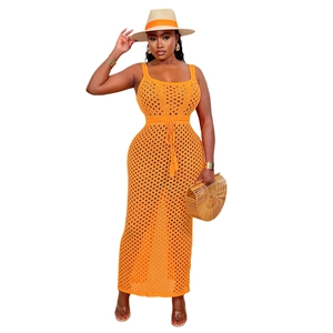 Détail d'une robe longue en maille crochetée orange avec cordon de serrage à pompons