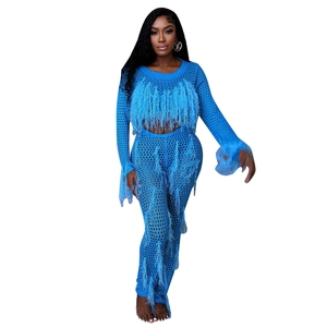 Detail of bright blue crochet knit set with long sleeves and ostrich feather fringe trim