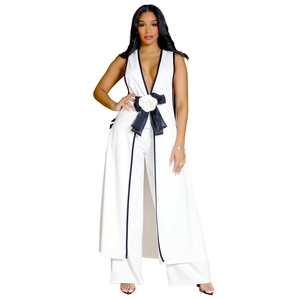 Detail view of white V-neck vest top with black trim and large 3D flower bow accent
