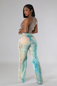 Detail of printed wide-leg pants featuring long fringe side seams and tie-dye patterns