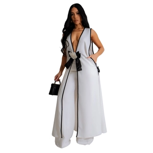 Detail of elegant white jumpsuit featuring a black bow and white camellia waist decoration