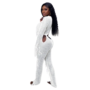 Detail view of white crochet knit set featuring side cut-outs and boho fringe tassels