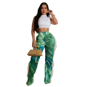 Detail view of high-waisted green printed wide leg trousers with white fringe side seams