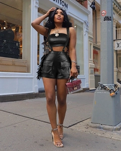 Détail d'un ensemble crop top en cuir PU noir brillant et short cargo taille haute