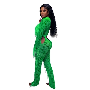 Detail of neon green crochet knit set with long tassels and intricate cutout mesh texture