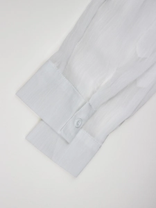 Detail of white sheer shirt cuff with vertical pleats and single button closure