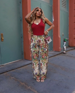 Detail of red slim fit vest paired with printed tassel cargo pants and studded handbag