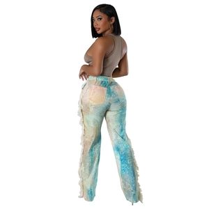 Detail of high-waist boho pants featuring colorful tie-dye patterns and white side fringe