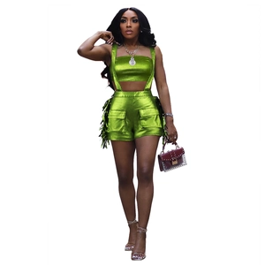 Détail d'un ensemble deux pièces vert métallisé avec crop top et short à franges mode