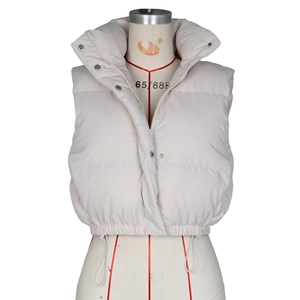 Detailed view of beige puffer vest featuring a stand collar and adjustable drawstring hem