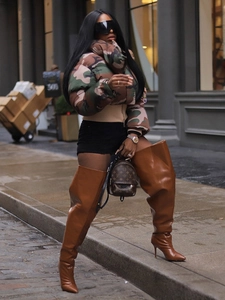 Women's stylish vintage camo print puffer jacket paired with brown leather stiletto boots