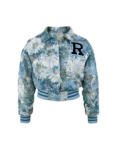 Detail of blue floral jacquard fabric with embroidered letter R patch on cropped jacket