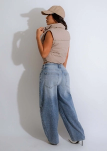 Street style view of beige stand-collar cropped puffer vest with wide-leg denim jeans